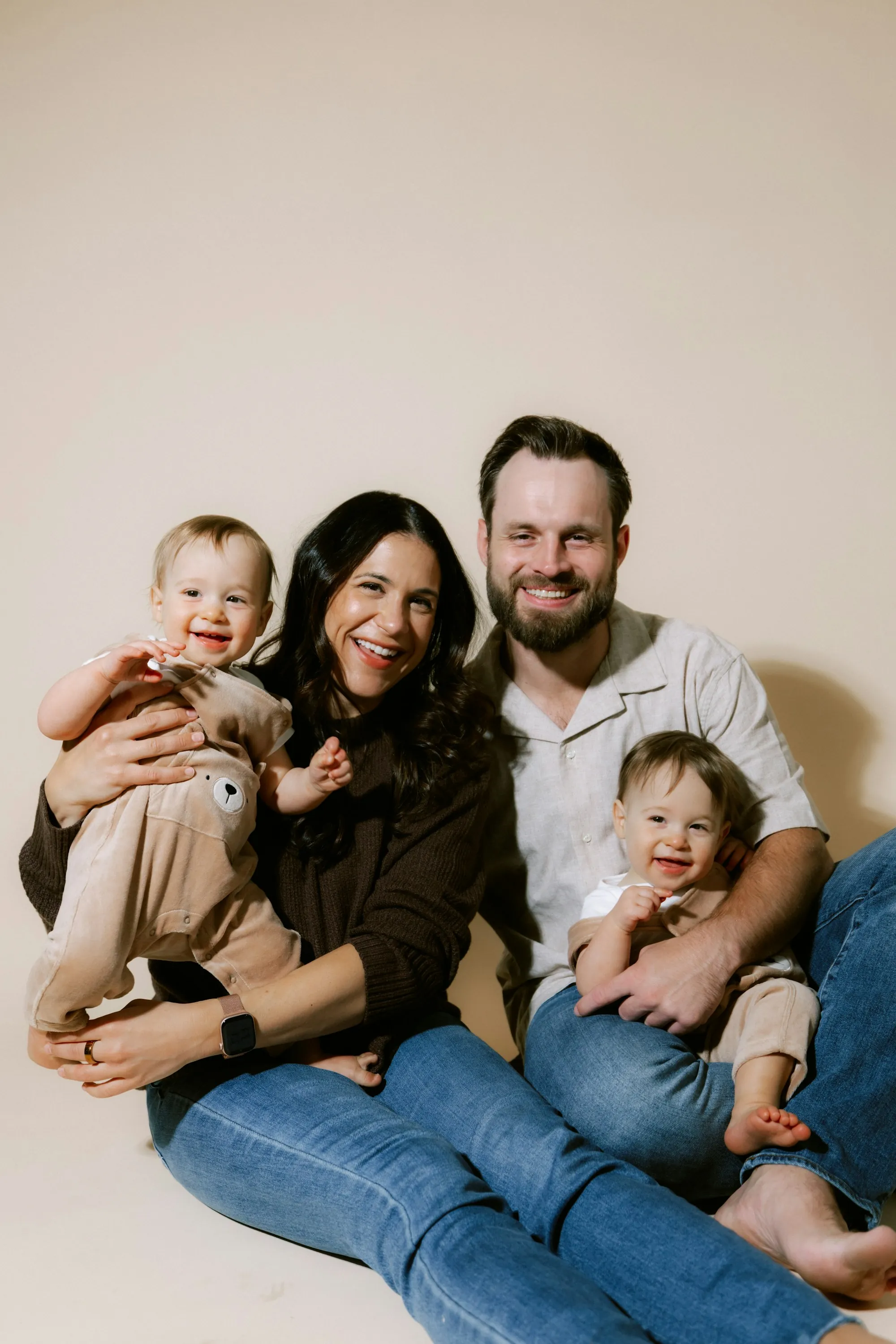 Parents smiling with their two babies on their laps