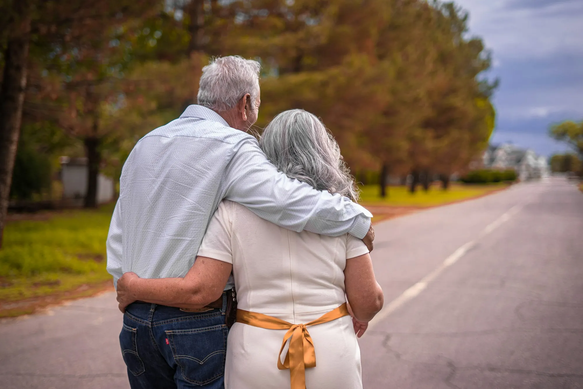 Senior couple embracing while walking along a quiet road