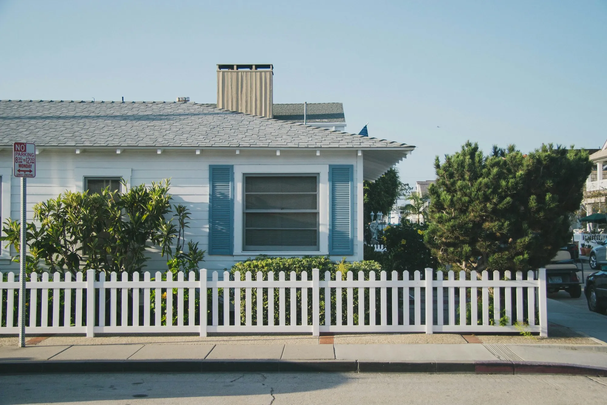 Small house behind a white picket fence