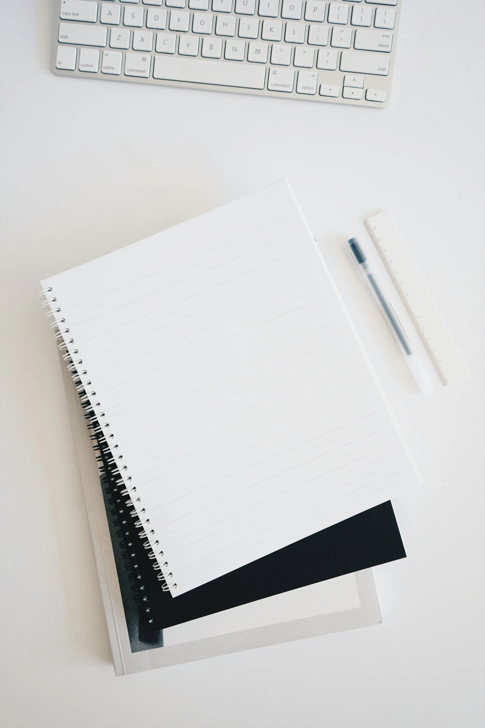 Spiral notebook with a pen on a white desk