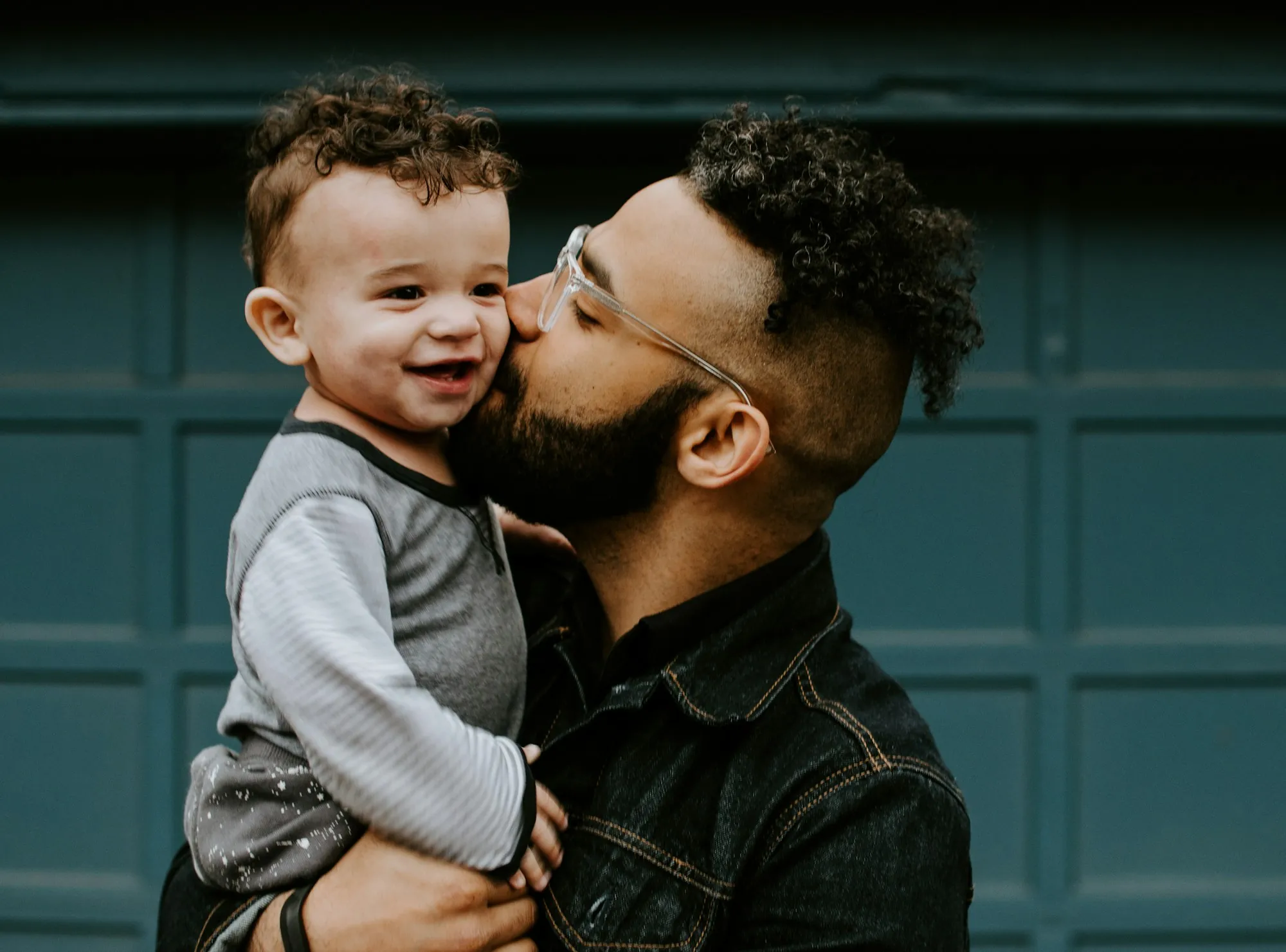 Father kissing his laughing baby son