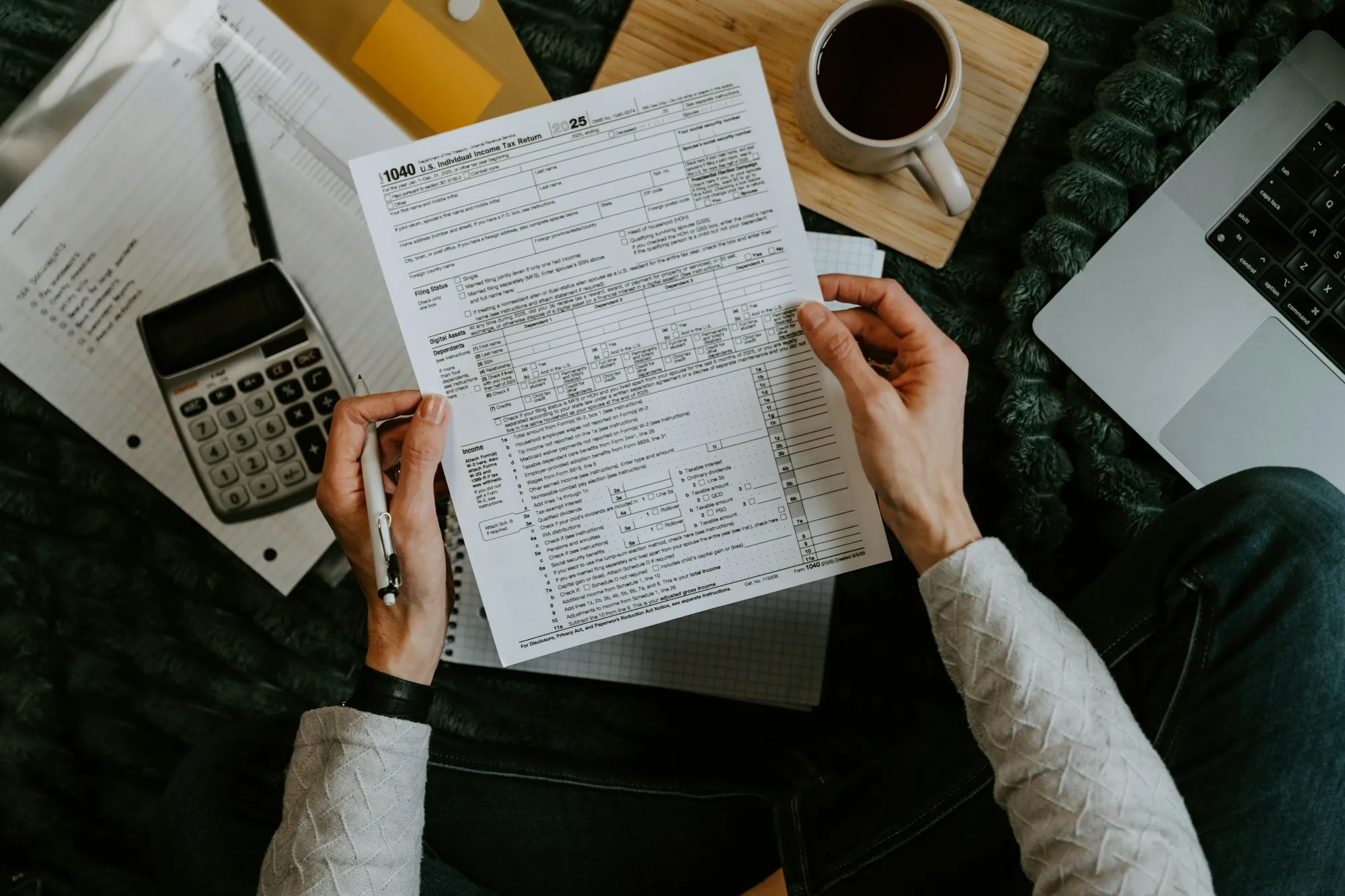 Hands holding a form next to a calculator